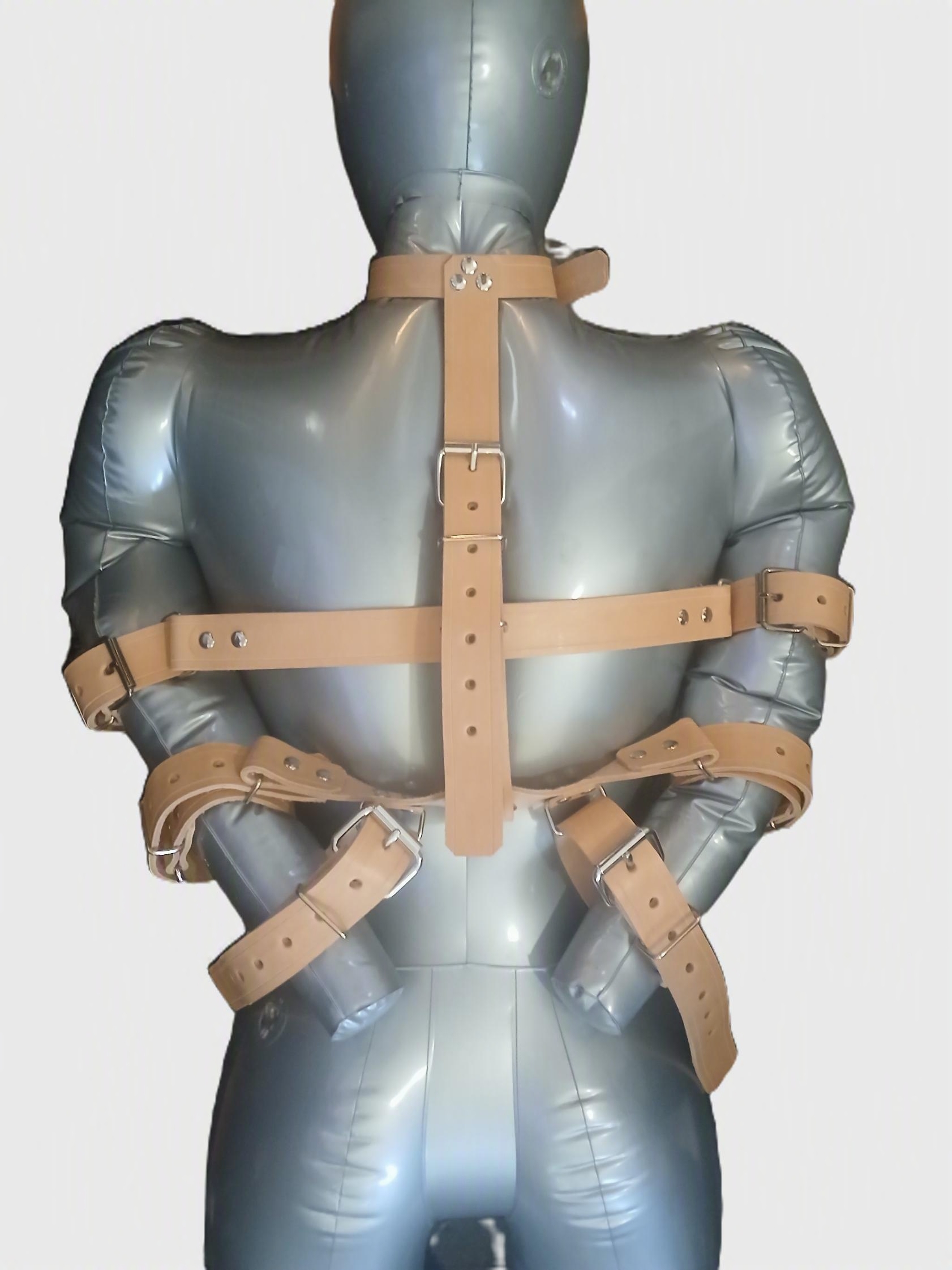 A mannequin wearing a restraint system that starts with a collar, goes down the back anf locks the biceps forearms and wrists.